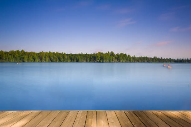 istock Long exposure lake scene in Canada with soft canoe movements. 2202682132