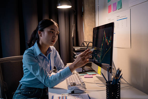 istock Asian businesswoman analyzing financial data on computer screen in office at night 2202686905
