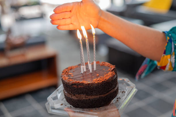 Person holding birthday cake with cancles