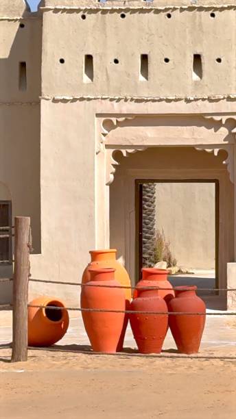 istock Traditional desert pottery enhances cultural aesthetics with clay forms set against backdrop of traditional Arabic design building. Pottery blends perfectly with architectural heritage. 2202691406