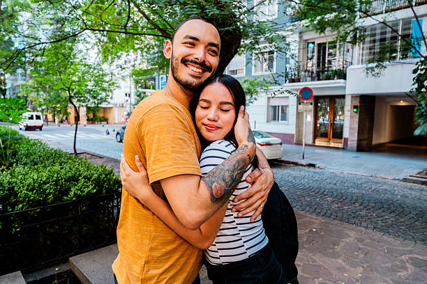 istock Friends embracing on the street 2202692211