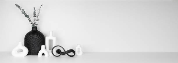 istock Modern black and white home decor on a shelf against a white wall banner 2202693832