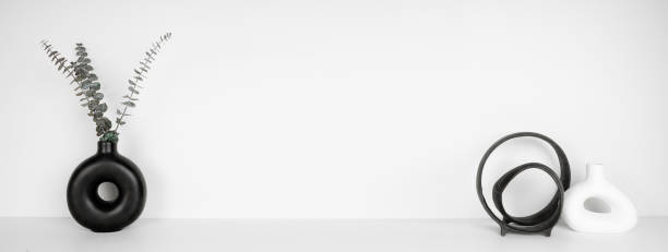 istock Modern black and white home decor on a shelf against a white wall banner 2202693834