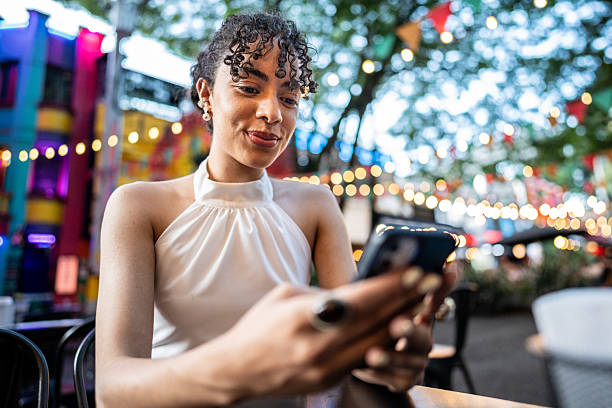 istock Young woman using mobile phone in a restaurant 2202696272