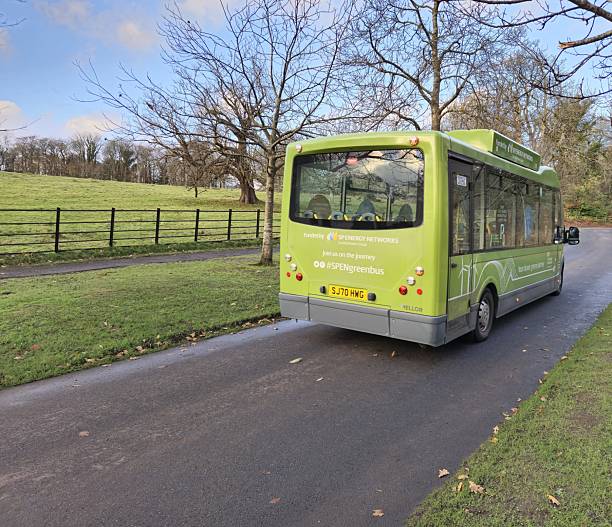 Glasgow, Scotland, UK - November 24, 2024: Electric shuttle bus at Pollok Country Park, Glasgow. At the background, green fields. Electric shuttle bus service (SPENERGYgreenbus) by SP Energy Networks (Scottish Power Group)