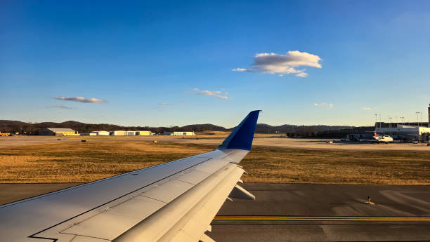 istock Looking out of an Airplane Window at Sunset while in Flight 2202703275