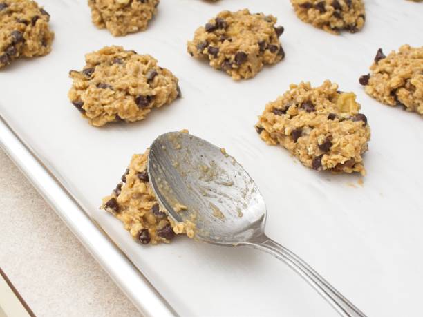 istock Cookie dough being pressed down onto parchment paper covered cookie sheet 2202706007