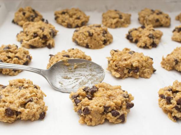 istock Cookie dough being pressed down onto parchment paper covered cookie sheet 2202706034