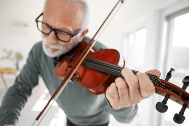 Senior Man Playing Violin in His Living Room