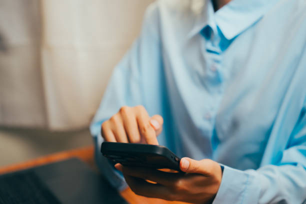 istock Woman Using Smartphone While Sitting at Table in Comfortable Indoor Setting, Business concept. 2202713589
