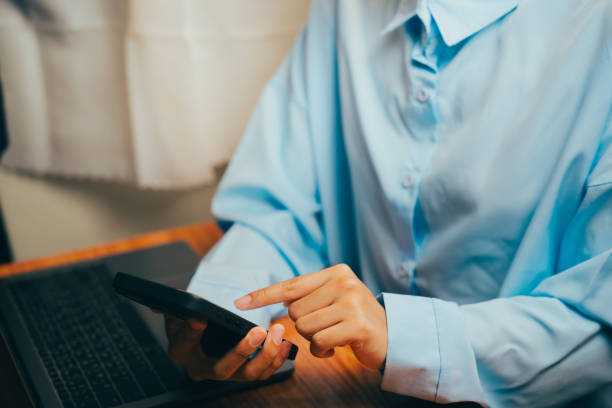 Focused individual utilizing smartphone, typing and working at desk, productivity themes, Business concept.