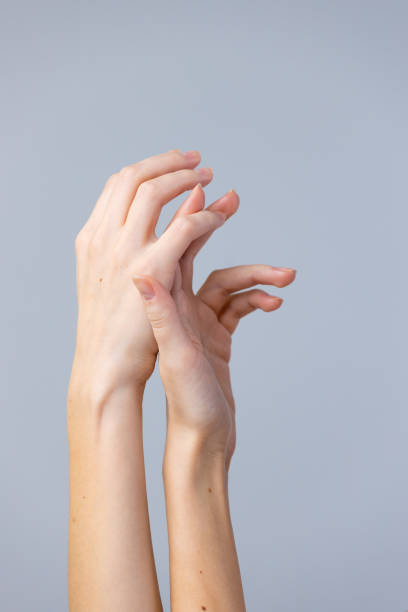 istock Elegant and Graceful Human Hands Intertwining Against a Soft Neutral Background, Emphasizing the Beauty and Artistry of Hand Movements and Gestures in Photography 2202718907