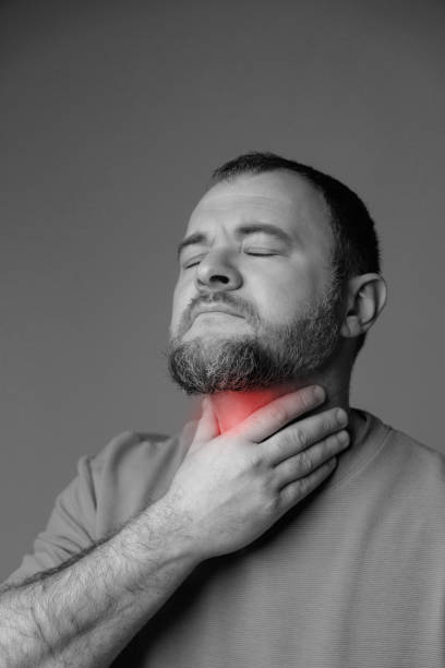 istock A man has a sore throat and neck due to a cold. 2202722298