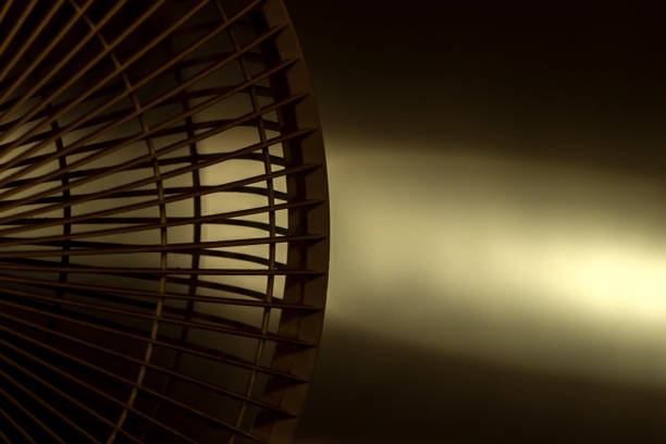 Close up of the halph electric fan with sunlight in yellow wall background in Brazil