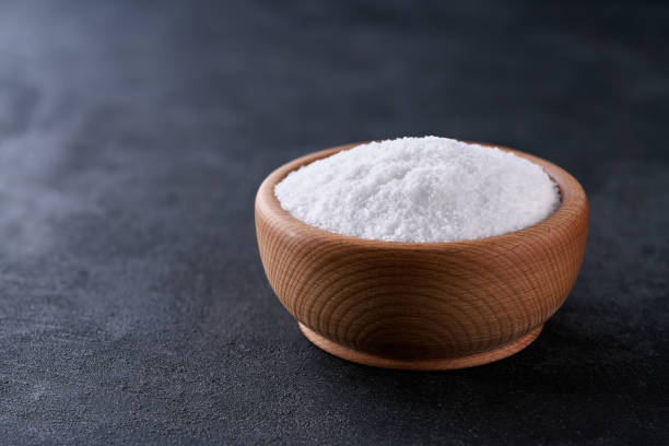 istock salt in a wooden bowl on a black stone table, selective focus. 2202723539