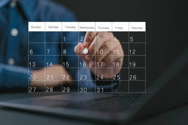 istock Businessman manages time for effective work. Calendar on the virtual screen interface. Highlight appointment reminders and meeting agenda on the calendar. Time management concept. 2202724564