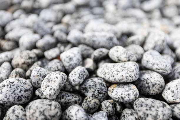 istock Bed of pebbles or smooth rocks and stones with light gray texture 2202724765