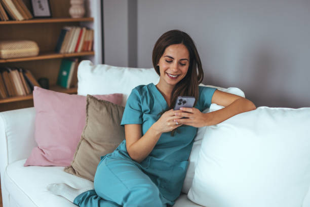 istock Smiling Nurse Relaxing At Home While Using Her Smartphone 2202738520