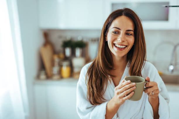 istock Smiling Woman Enjoying Morning Coffee in Cozy Kitchen Setting 2202738567