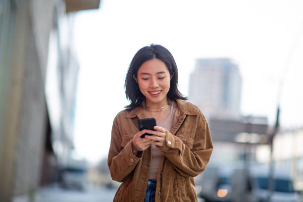 istock young woman using mobile phone in city 2202739494