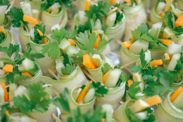 Cucumber appetizers filled with carrots cheese and parsley offer a light healthy option for party food Vegetarian and visually appealing