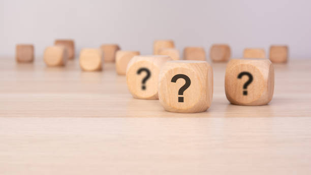 istock three wooden blocks with question marks over a gray background with copy space 2202750051