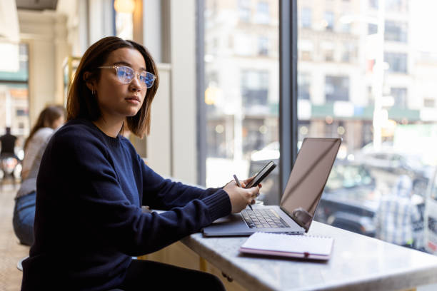 istock Contemplative Woman Working in Cafe Morning 2202751181