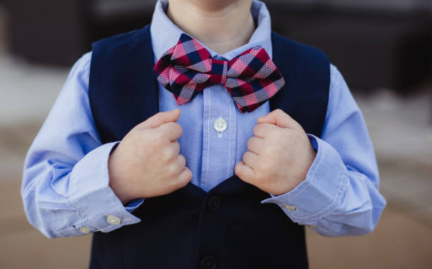Little boy in vest and bowtie as ring bearer at wedding ceremony