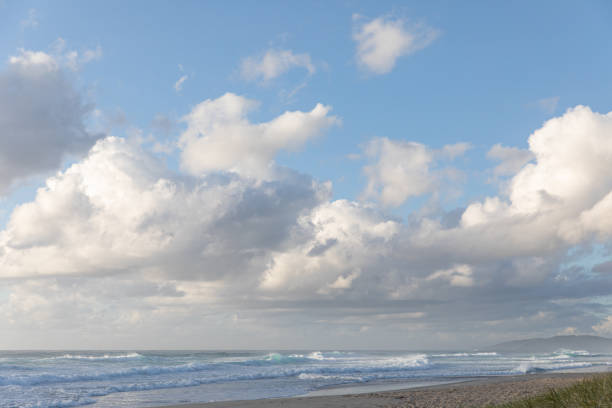Beautiful beach landscape in Byron Bay on an early morning in Summer with dunes, cliffs, clouds and waves