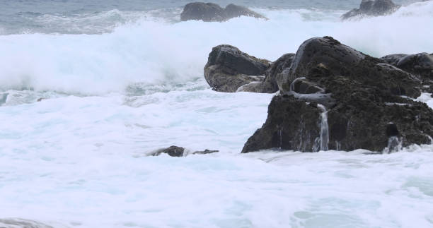 istock waves crashing against the rock 2202768711