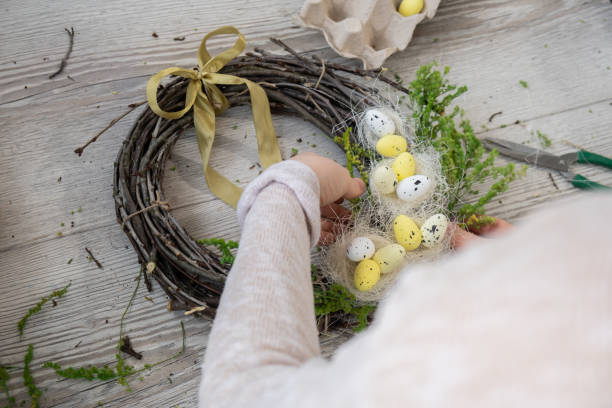 istock Step by step instruction of making handmade Easter wreath made of sustainable materials decorations in yellow color. Female hands creating craft homemade decor. Easter celebration gift present ideas 2202770529