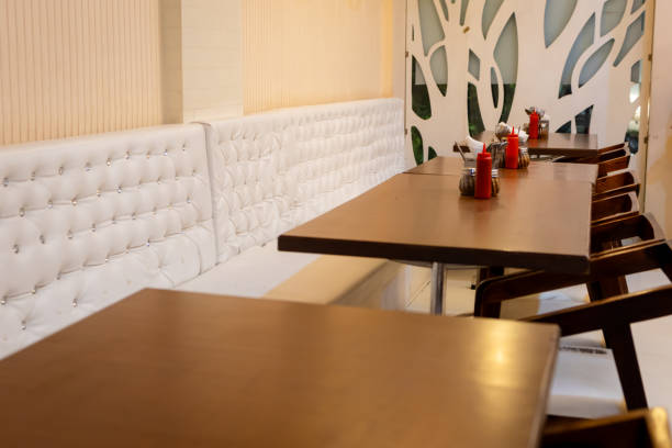 Cropped shot of a coffee cup on a table and two chairs in an empty coffee shop during the day