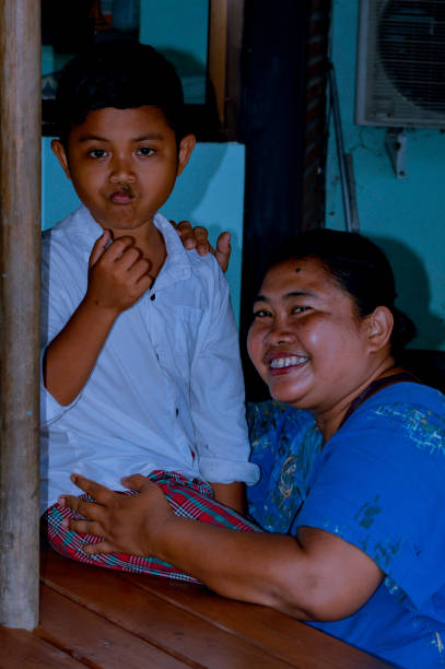 A touching moment captured between a mother and her young son at a cozy cafe located in a beautiful garden park, showcasing their love and connection.