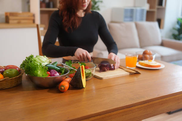 istock A white woman in workout clothes makes vegetable and fruit juice using a blender on the kitchen table, recommending eating vegetables and fruits online to support healthy, digestion, weight control 2202777842