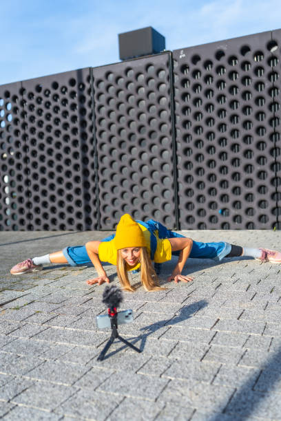 istock Young blonde dancer recording herself dancing in urban environment 2202780949
