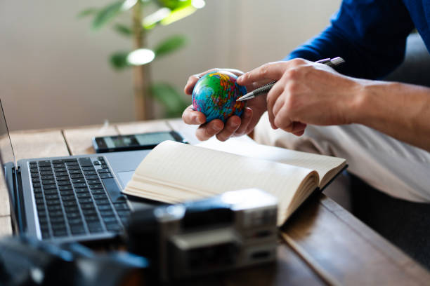 istock Travel blogger planning next trip with globe, laptop and notebook 2202784307