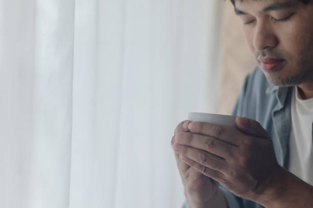 istock A young man is drinking a cup of coffee. 2202784548