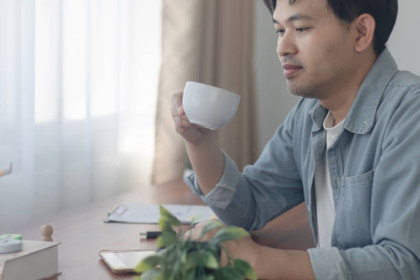 istock A young man is drinking a cup of coffee. 2202784552