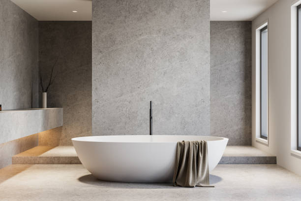 istock Minimalist bathroom interior with modern freestanding bathtub in gray stone setting. 3D Rendering 2202785660