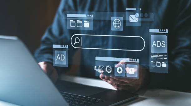 istock Digital search engine interface concept with ads and icons on a transparent overlay over a laptop screen. 2202787000