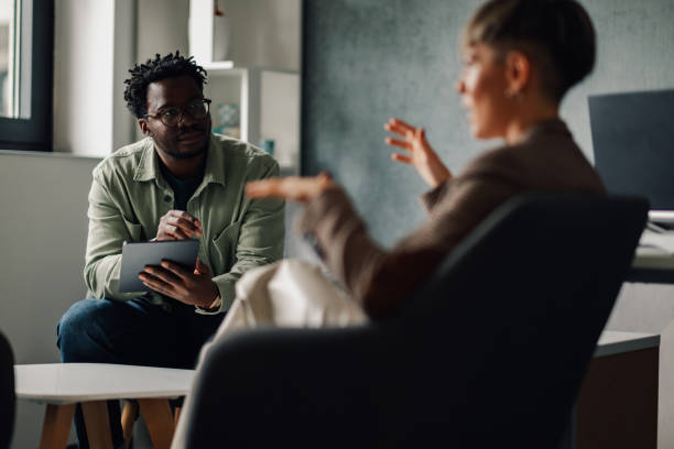 istock Colleagues collaborating and discussing work with tablet in modern office 2202789148