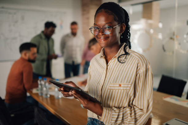 istock Project manager smiling and using digital tablet during office meeting 2202789150