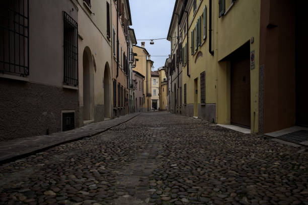 Cobbled alley that narrows at its end in an italian town on a cloudy day