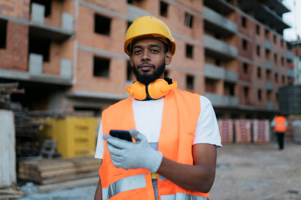 istock Young african man in safety wear working at construction site 2202791938