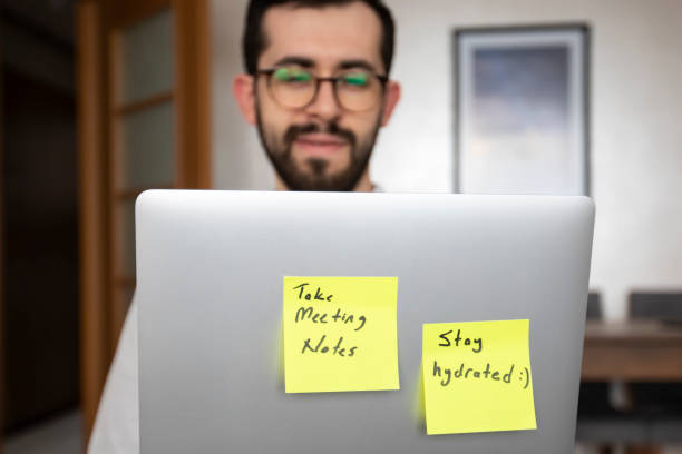 istock A man in glasses and a white shirt.His laptop has two pop-up notes: 