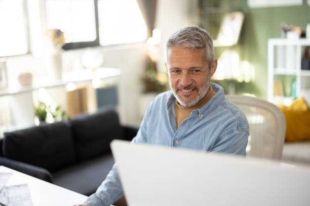 istock Expert architect refining plans in his home office 2202801776