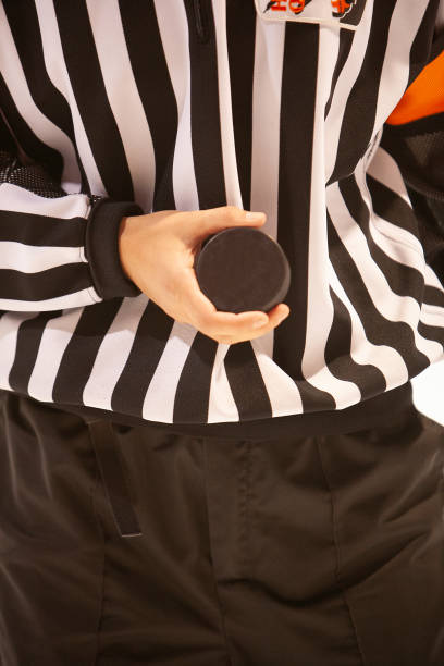 istock Head female referee with the puck during a hockey match 2202802152
