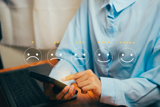 istock Person Evaluating Feedback on Smartphone with Rating Stars and Emoticons in a Modern Setting, Business concept. 2202802272