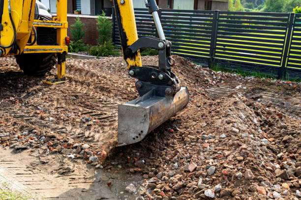 istock A backhoe loader picks up rubble with a telescopic bucket to level the dirt road. 2202804570