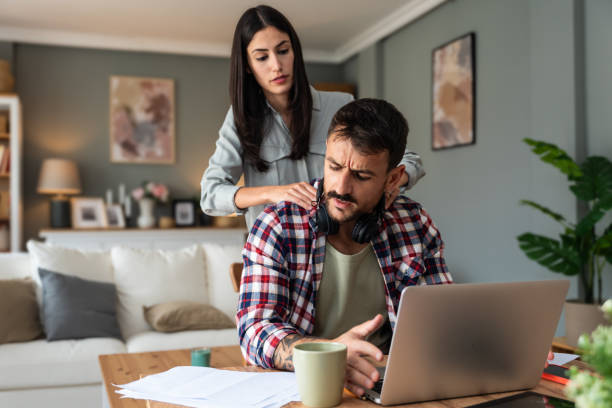istock Young woman support her man massaging him while he work on laptop computer in home office, stressed with neck or headache pain. Love and respect. Couple simple living concept. 2202804985